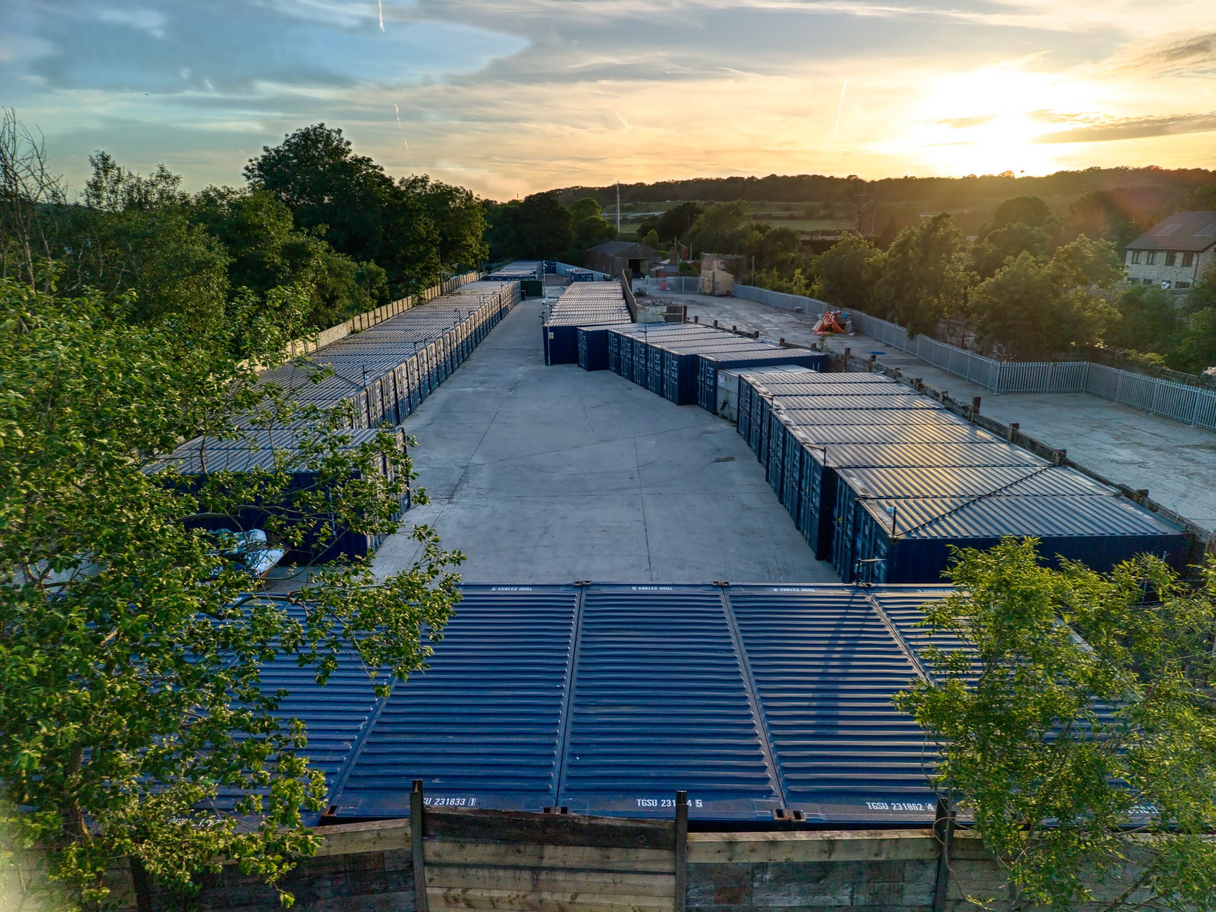 The Henbury self storage site seen from above at sunset, container rows framed by trees