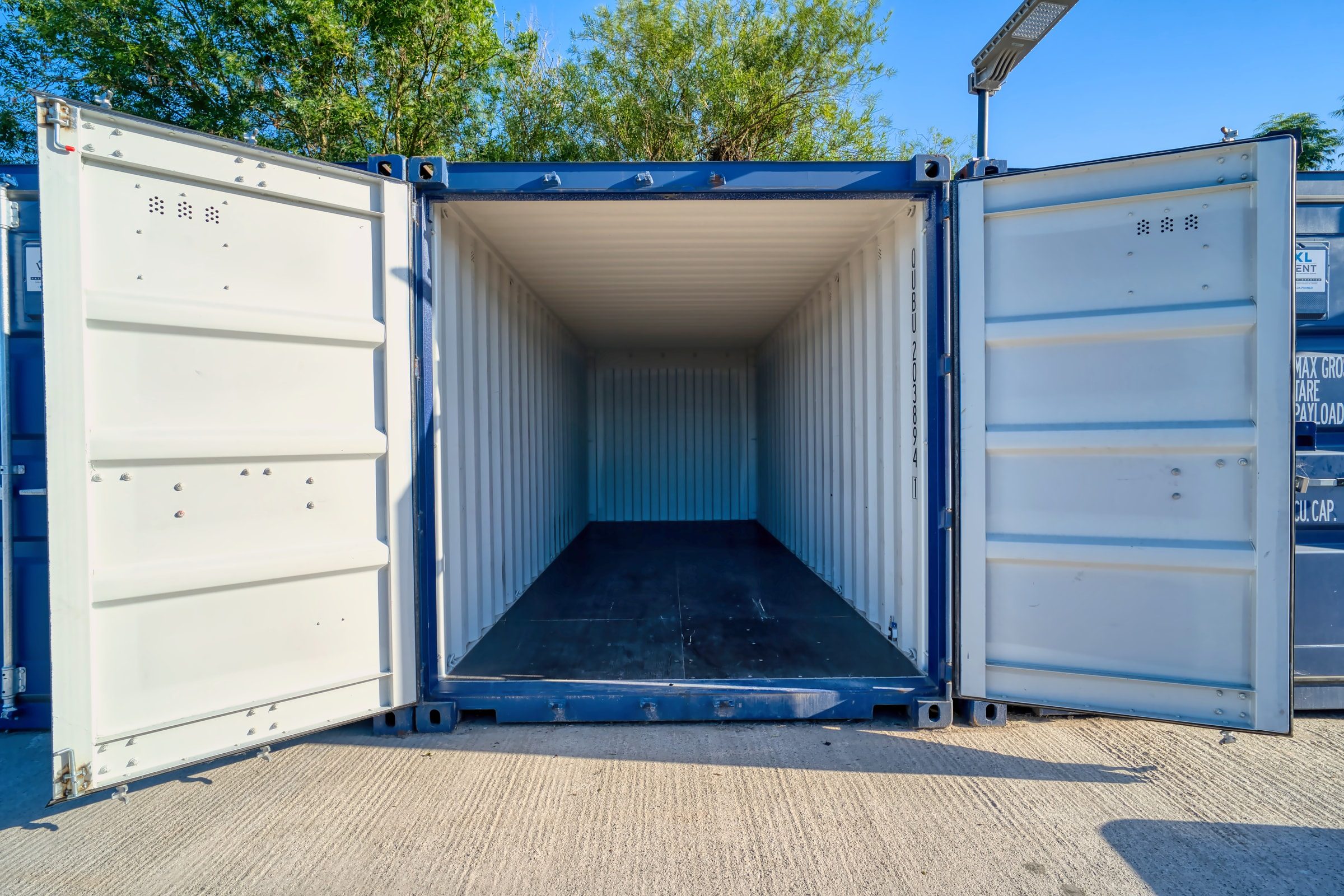 Steel container standing open with a clean, dry interior and timber floor ready to load